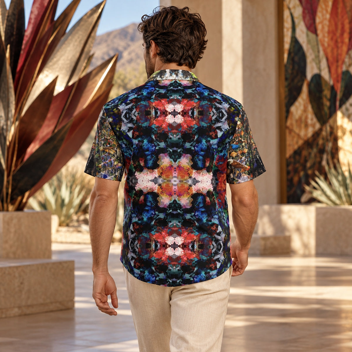 Back view of man wearing Desert Flowers Oasis ArtDogs men's short sleeve shirt at a contemporary desert gallery